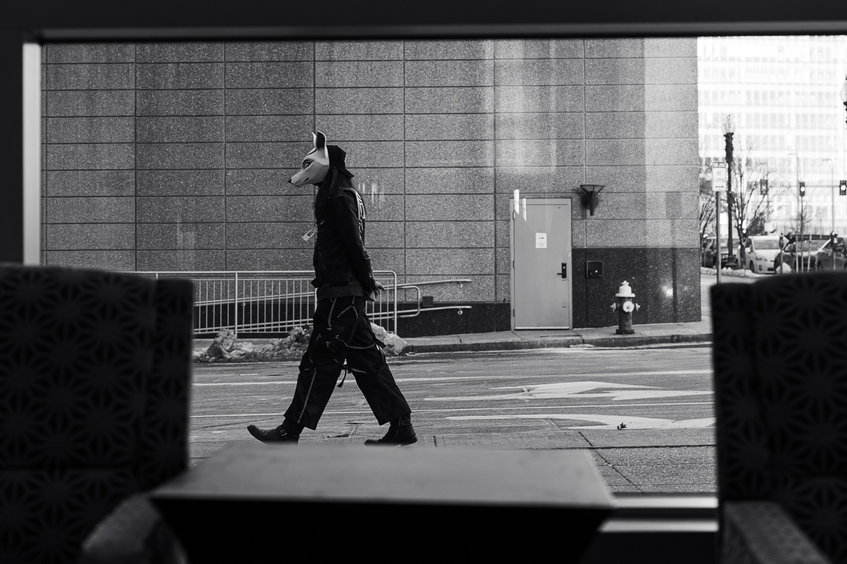 A person in a dog mask walking outside